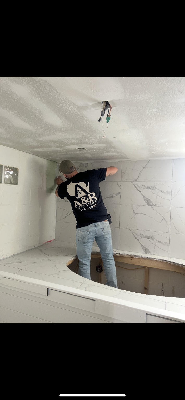 A&R carpenter fitting large-format wall tile during a bathroom renovation