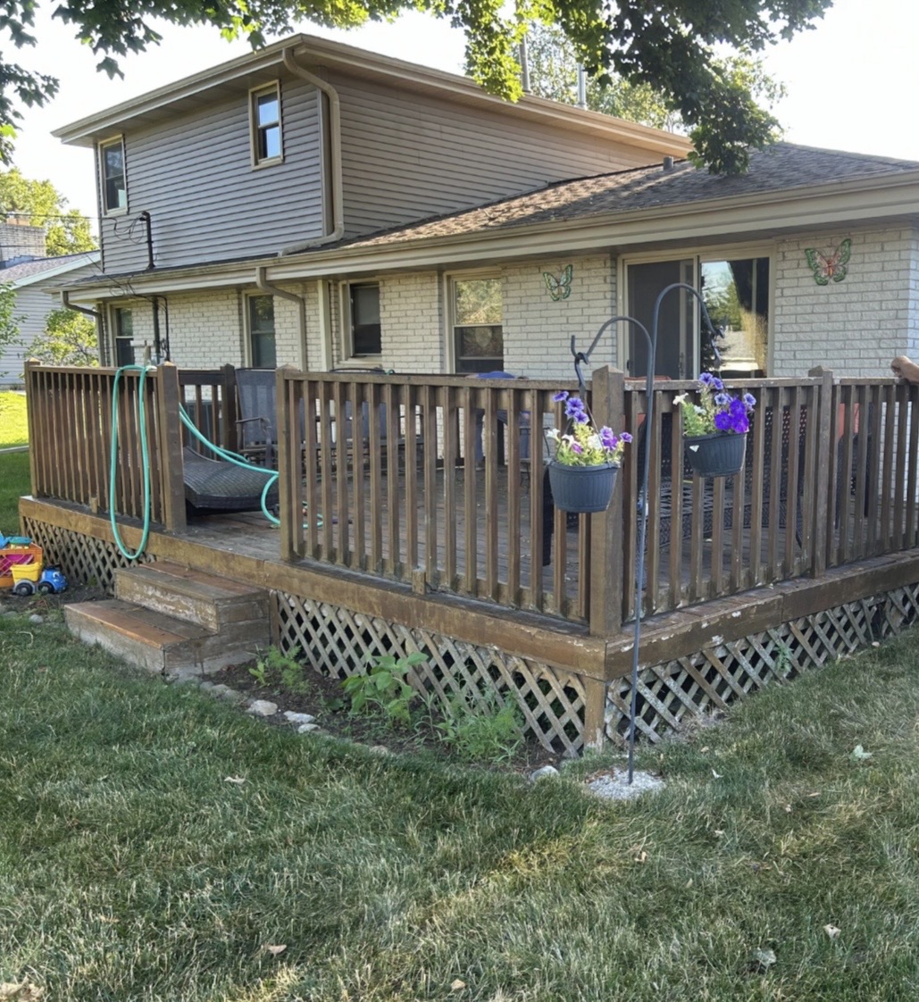 Before: weathered wood deck with wood railings and lattice