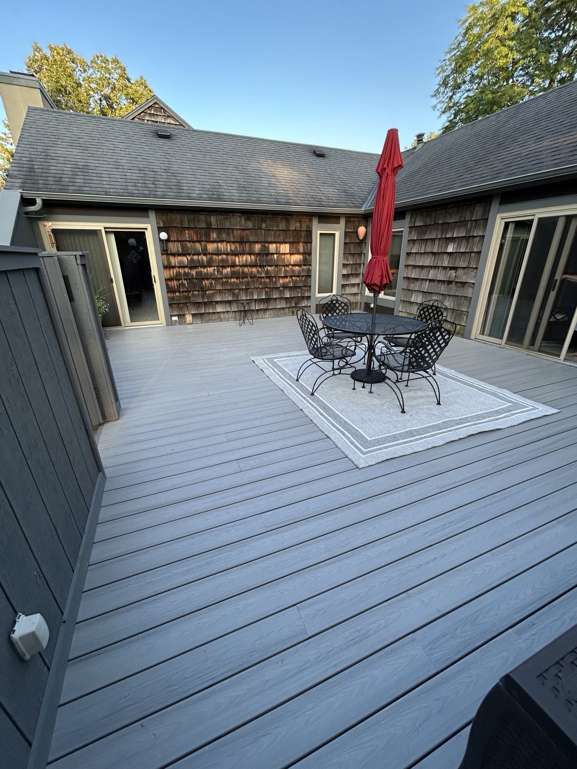 A&R composite deck resurfacing with gray boards and a courtyard dining area