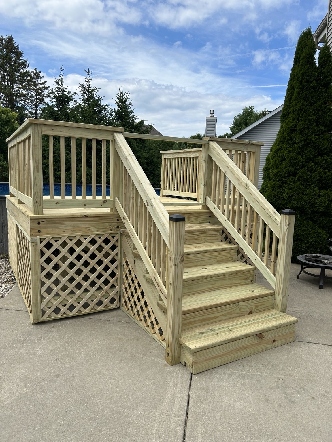 New wood pool deck with stairs, railings, and lattice skirting