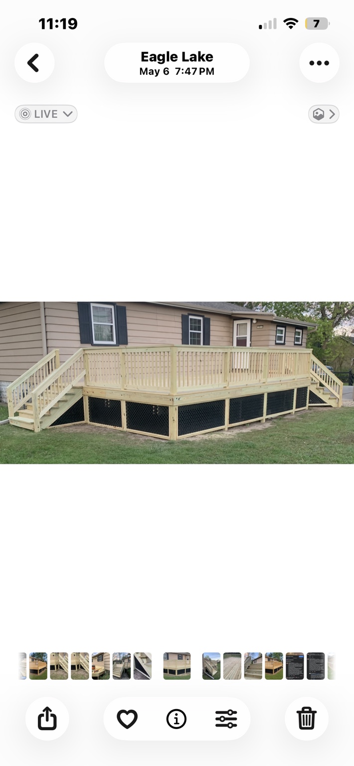 Wood deck with two stairways, wood railings, and black lattice skirting.